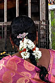 Scented garlands of fresh flowers swaying in women black hair near the Swamimalai temple. 